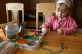 liten flicka målar på bordet